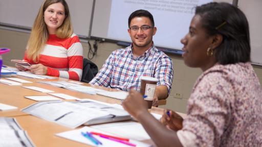 Three students talking during graduate class