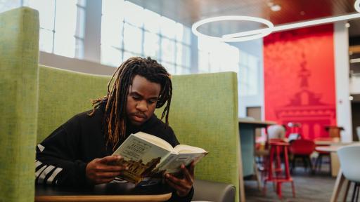 A North Central College student reading a textbook.